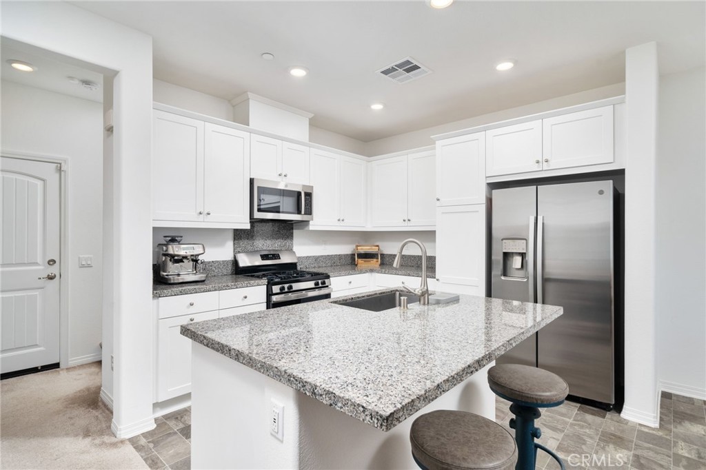 16502 Casa Grande Avenue, Unit 102 Fontana, CA 92336 - Photo 7 of 41 a kitchen with stainless steel appliances granite countertop a sink refrigerator and cabinets