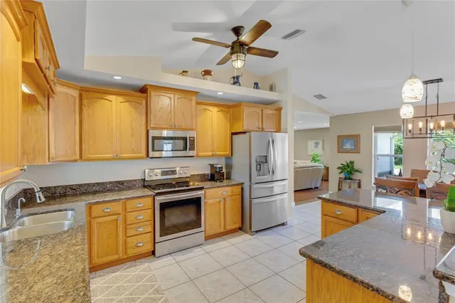 a kitchen with a stove a sink a dining table and chairs