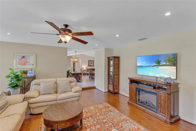 a bedroom with a bed a dresser and wooden floor