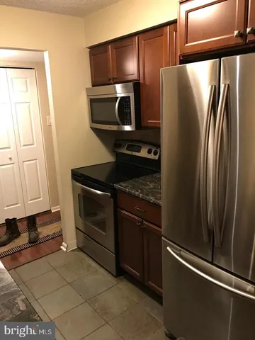a metallic refrigerator freezer sitting in a kitchen