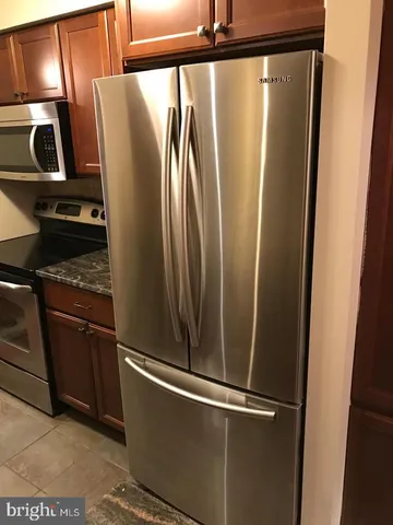 a metallic refrigerator freezer sitting in a kitchen