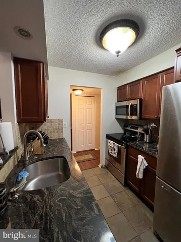 a kitchen with a sink cabinets and stainless steel appliances