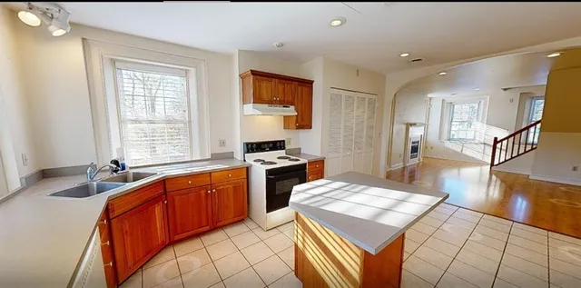 a large kitchen with a sink and a large window