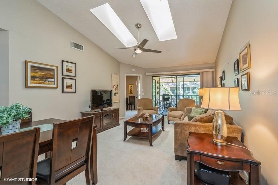 a living room with furniture a flat screen tv and a large window