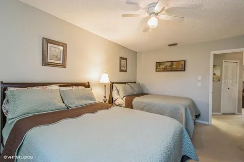 a bedroom with two large bed and a chandelier