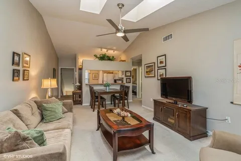 a living room with furniture a flat screen tv and kitchen view