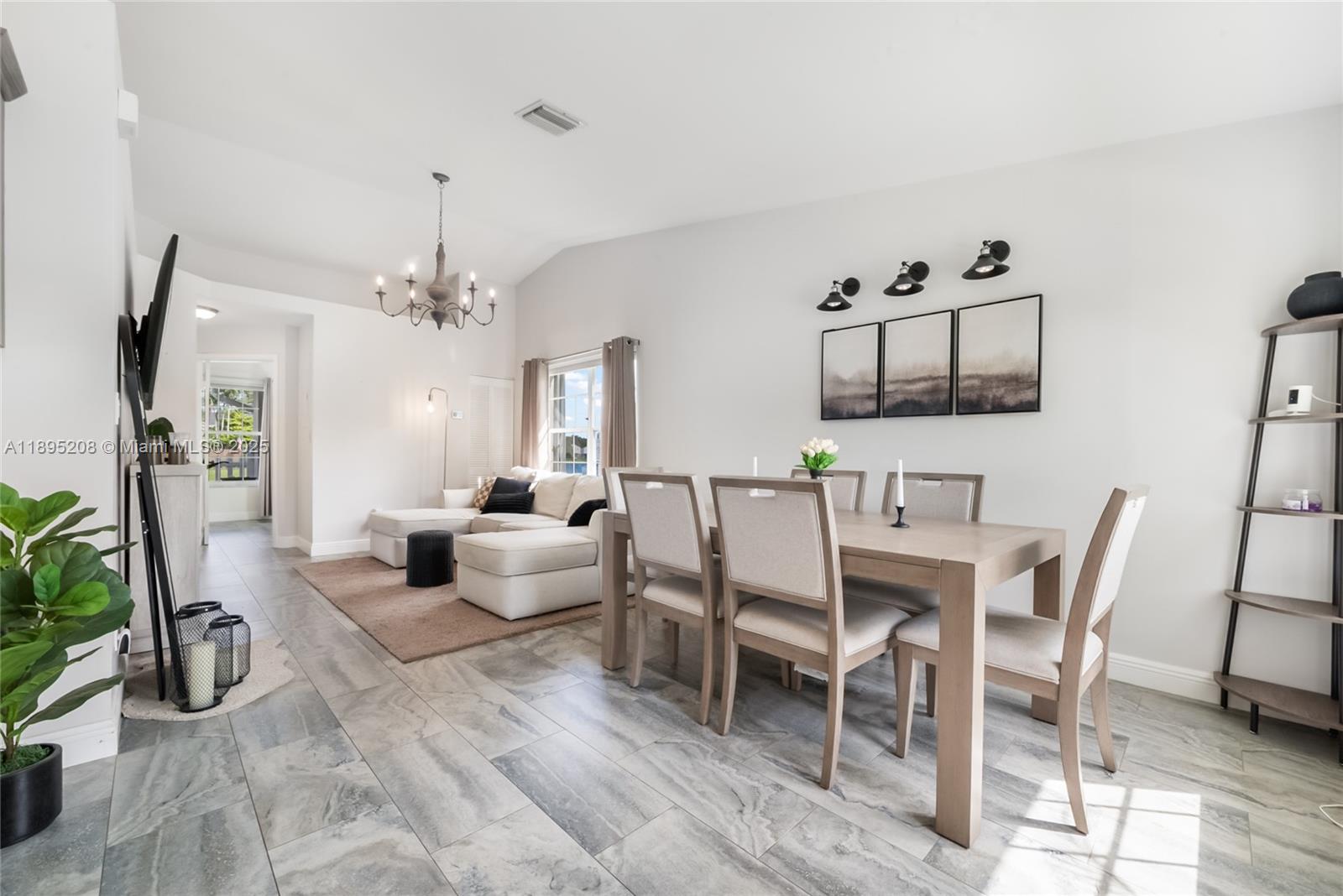 12525 Southwest 147th Terrace Miami, FL 33186 - Photo 4 of 15 a living room with furniture and a chandelier