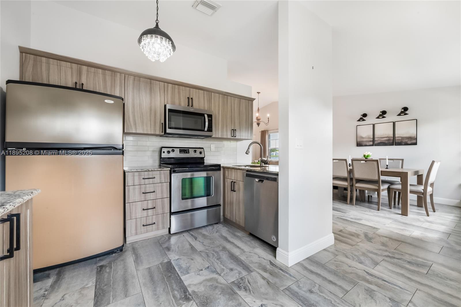 12525 Southwest 147th Terrace Miami, FL 33186 - Photo 6 of 15 a kitchen with microwave a stove and refrigerator