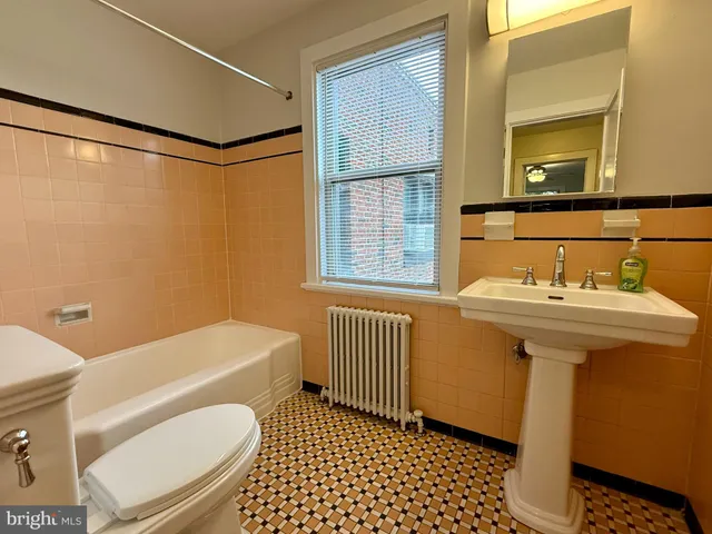 a bathroom with a sink a mirror a toilet and bathtub