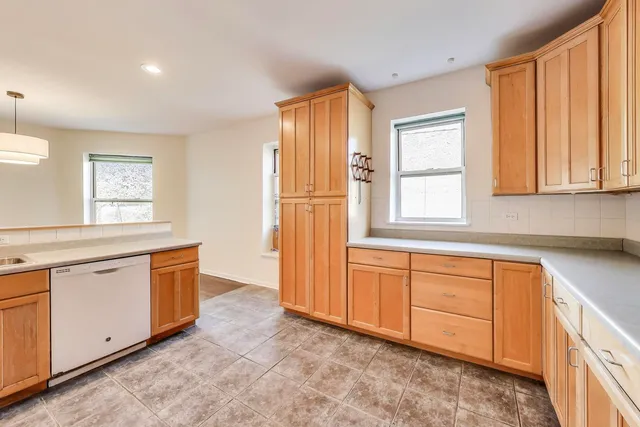 a utility room with a sink a cabinetry and a window
