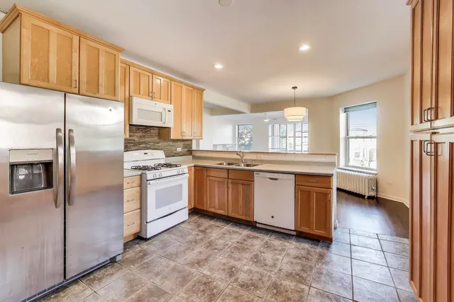 a room with stainless steel appliances granite countertop cabinets and a dresser