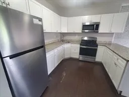 a kitchen with stainless steel appliances granite countertop a refrigerator a stove a sink and a microwave