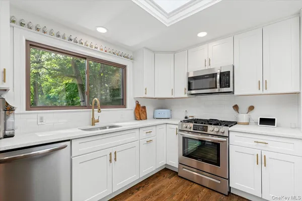 a kitchen with sink a microwave and cabinets