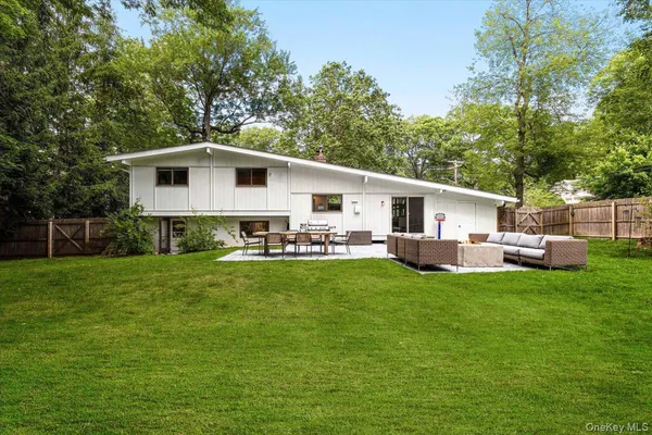 a white house that has a big yard with wooden fence