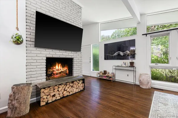 a living room with furniture a flat screen tv and a fireplace