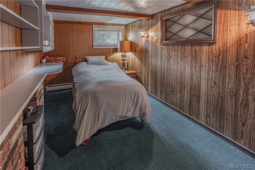 6775 Bear Ridge Road Pendleton, NY 14094 - Photo 33 of 48 Rich wood paneling paired with textured carpet creates a cozy and rustic cabin-like atmosphere.