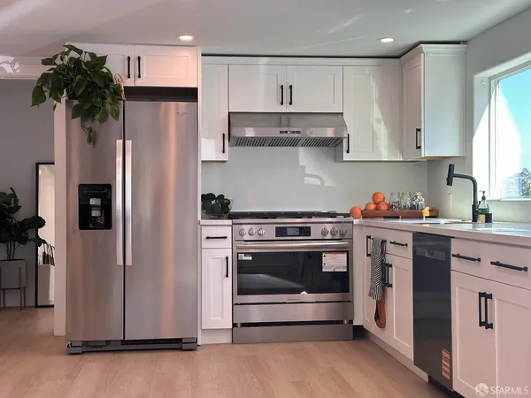 a kitchen with stainless steel appliances a stove a refrigerator and cabinets