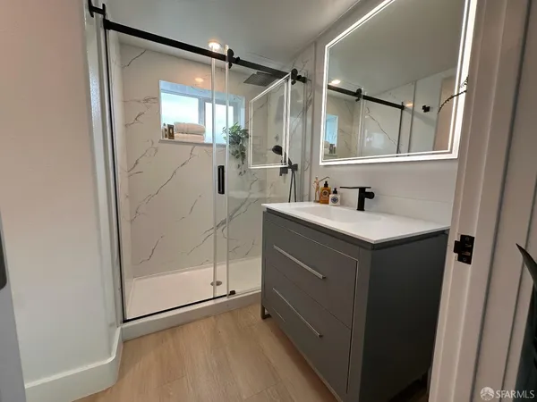 a bathroom with a sink mirror and shower