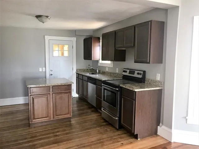 a kitchen with stainless steel appliances granite countertop a stove a sink and a microwave