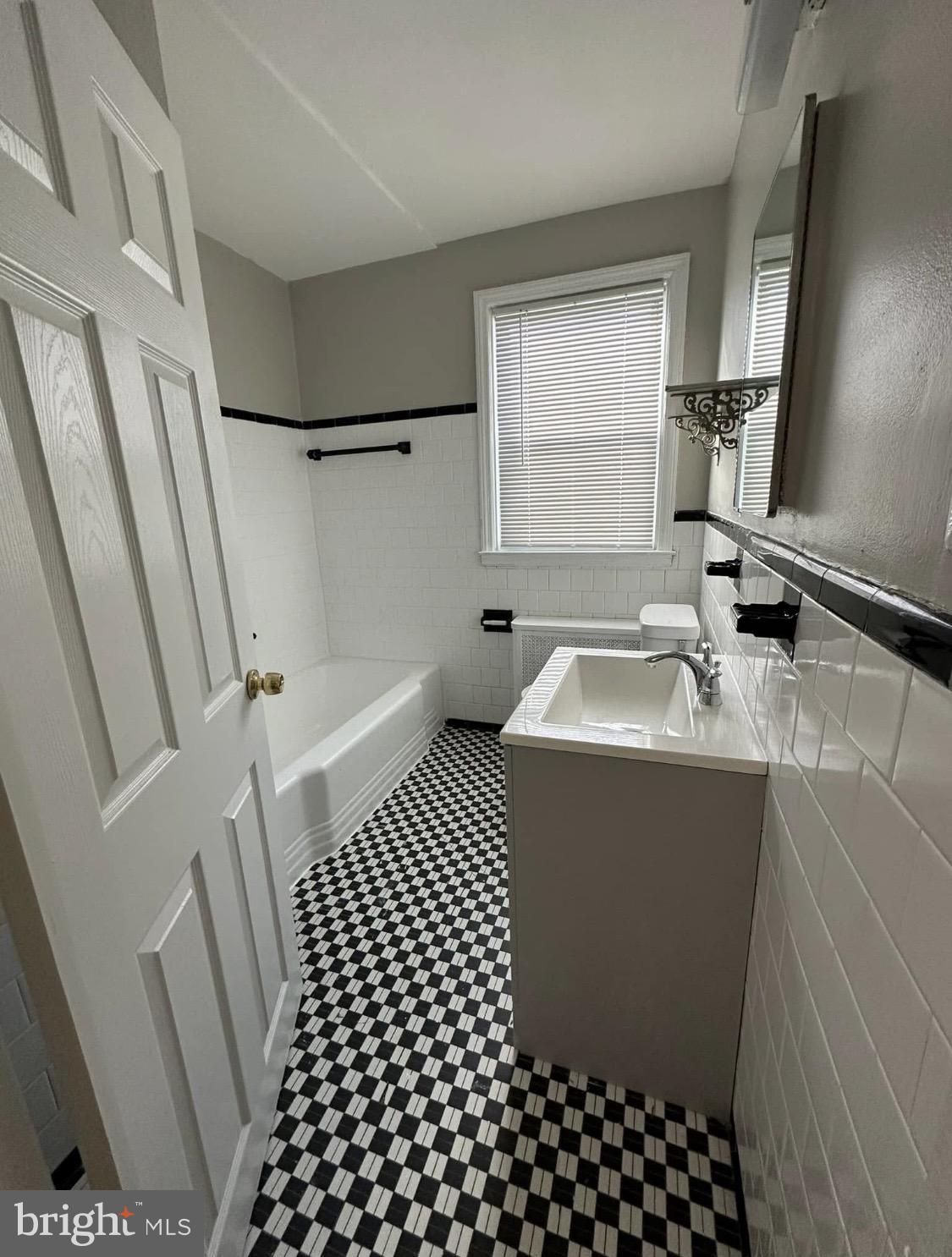 9904 Harford Road Baltimore, MD 21234 - Photo 11 of 15 a bathroom with a sink a toilet a shower a window and vanity