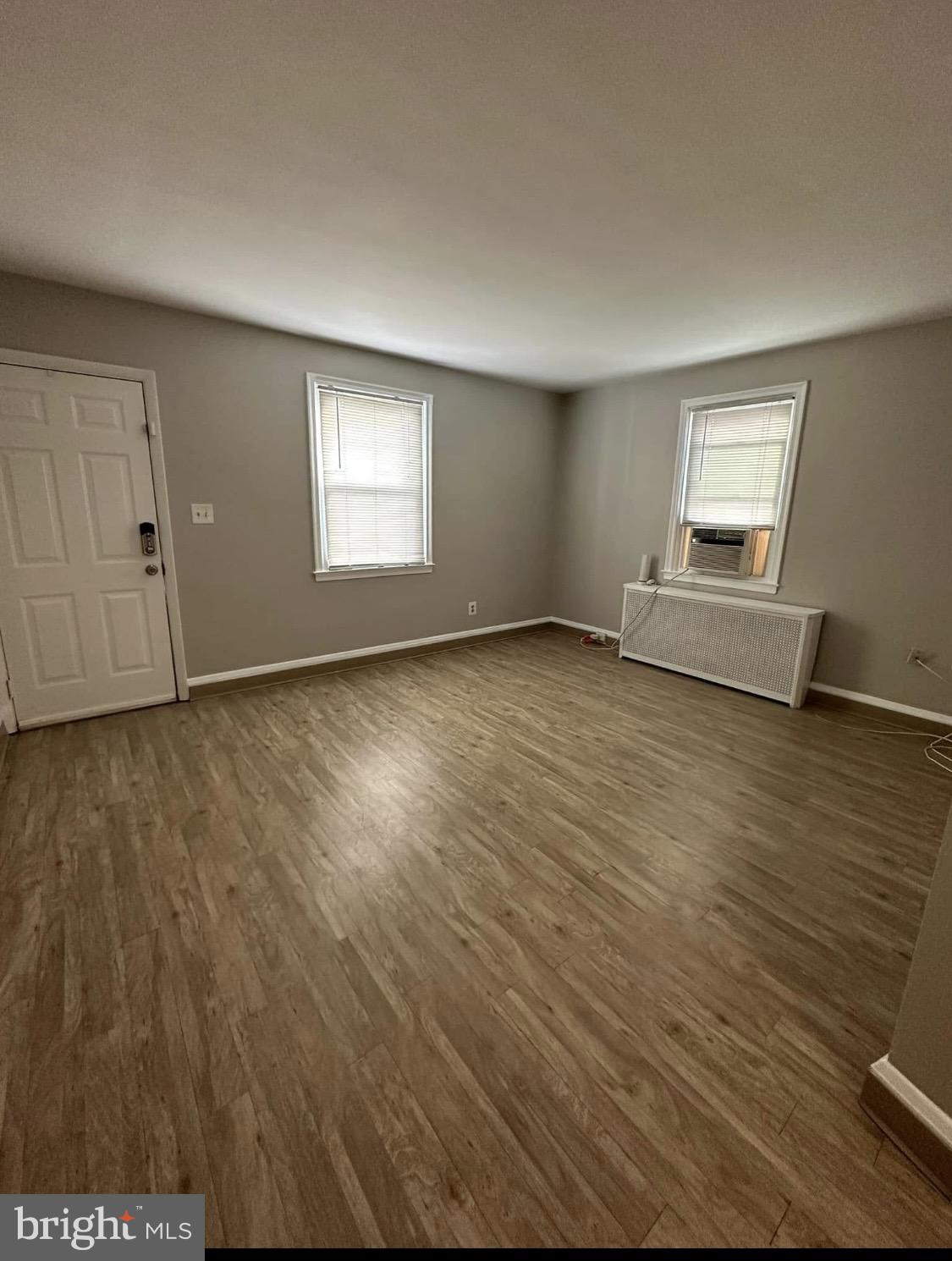 9904 Harford Road Baltimore, MD 21234 - Photo 15 of 15 an empty room with wooden floor and windows