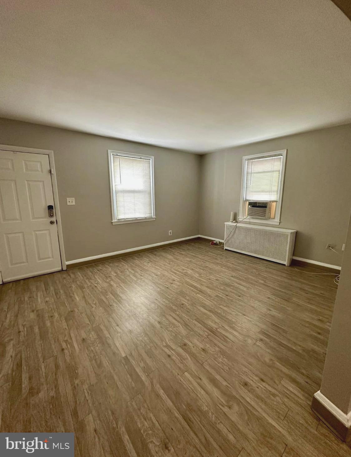 9904 Harford Road Baltimore, MD 21234 - Photo 6 of 15 an empty room with wooden floor and windows