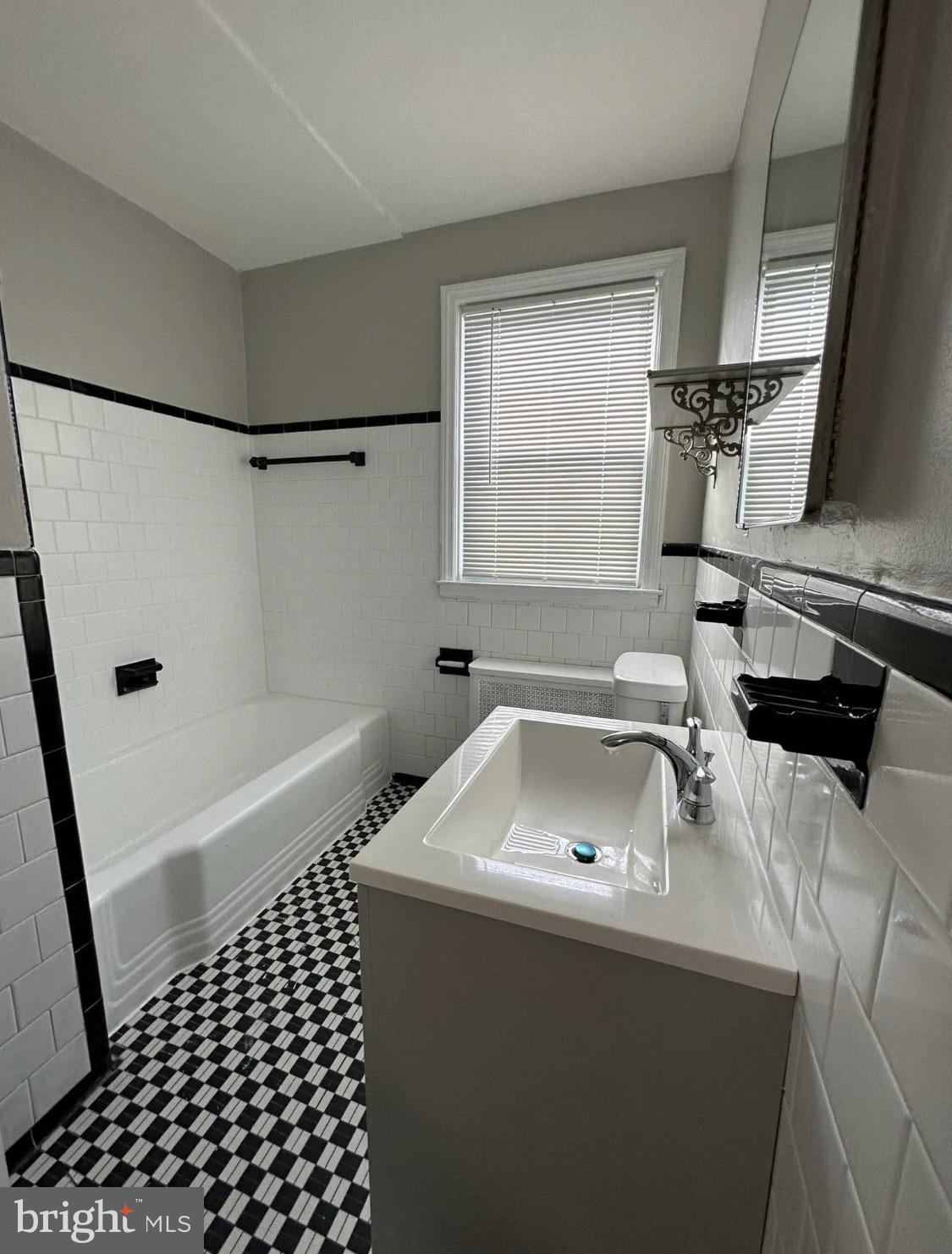 9904 Harford Road Baltimore, MD 21234 - Photo 9 of 15 a bathroom with a sink a toilet and a bathtub