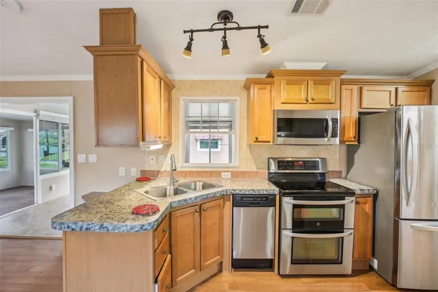 a kitchen that has a sink cabinets counter space and stainless steel appliances