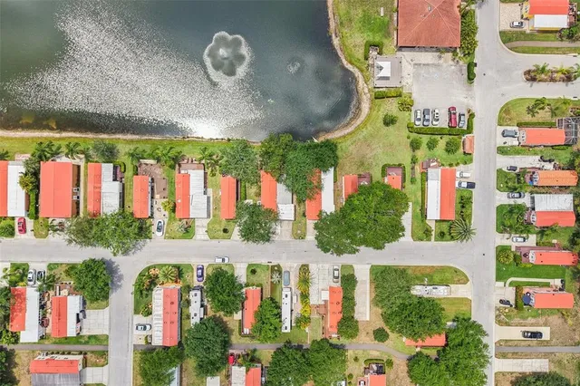 an aerial view of residential houses with outdoor space and trees