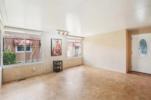 a view of a big room with wooden floor and windows