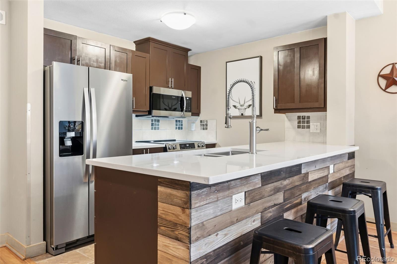 910 Copper Road, Unit 621 Frisco, CO 80443 - Photo 8 of 31 a kitchen with a refrigerator a sink and chairs