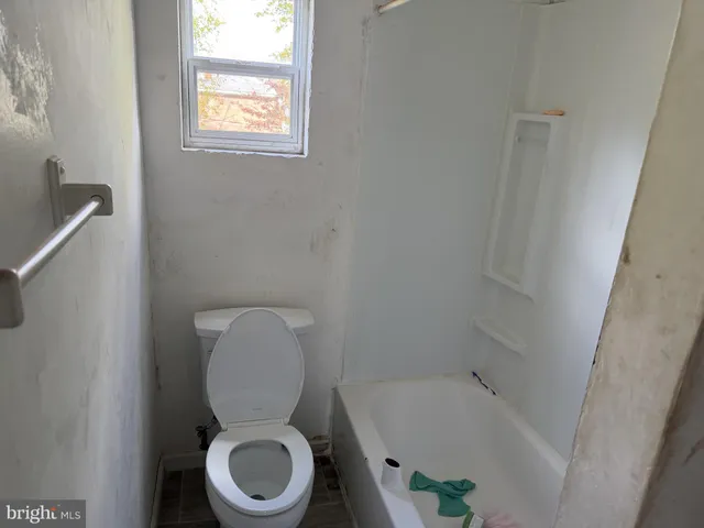 a white toilet sitting next to a bath tub