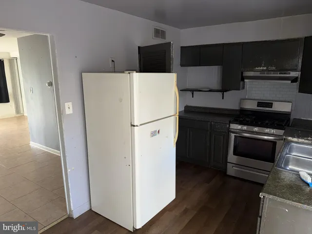 a white refrigerator freezer and a stove sitting inside of a kitchen