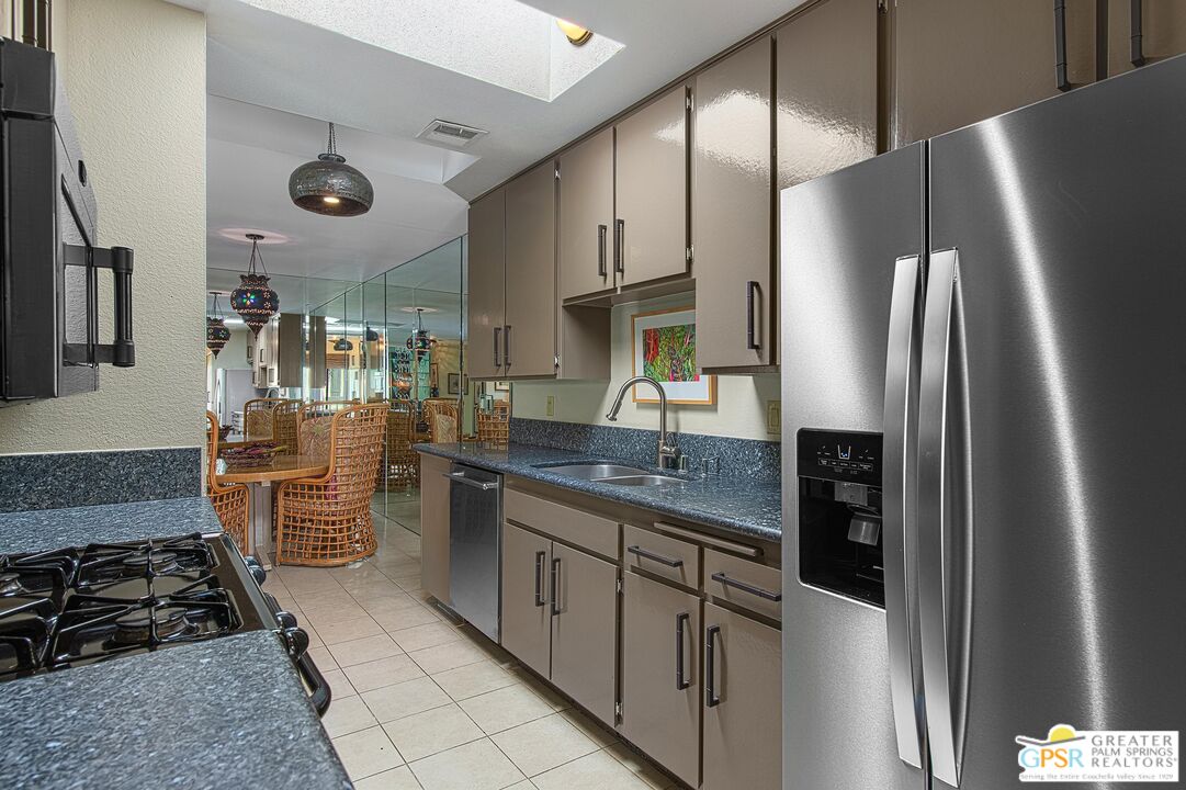 1177 East Alejo Road Palm Springs, CA 92262 - Photo 11 of 33 a kitchen with stainless steel appliances granite countertop a refrigerator and a stove