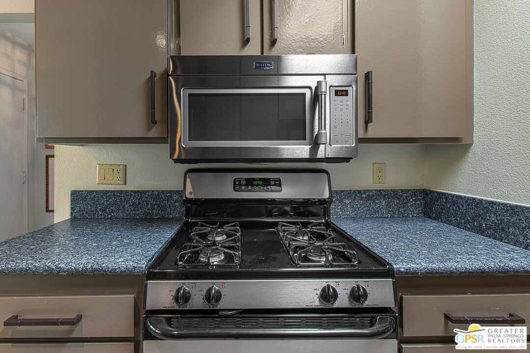 1177 East Alejo Road Palm Springs, CA 92262 - Photo 12 of 33 a stove top oven sitting inside of a kitchen