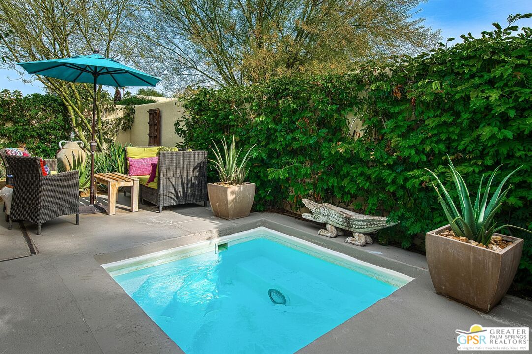 1177 East Alejo Road Palm Springs, CA 92262 - Photo 17 of 33 a view of a backyard with table and chairs under an umbrella