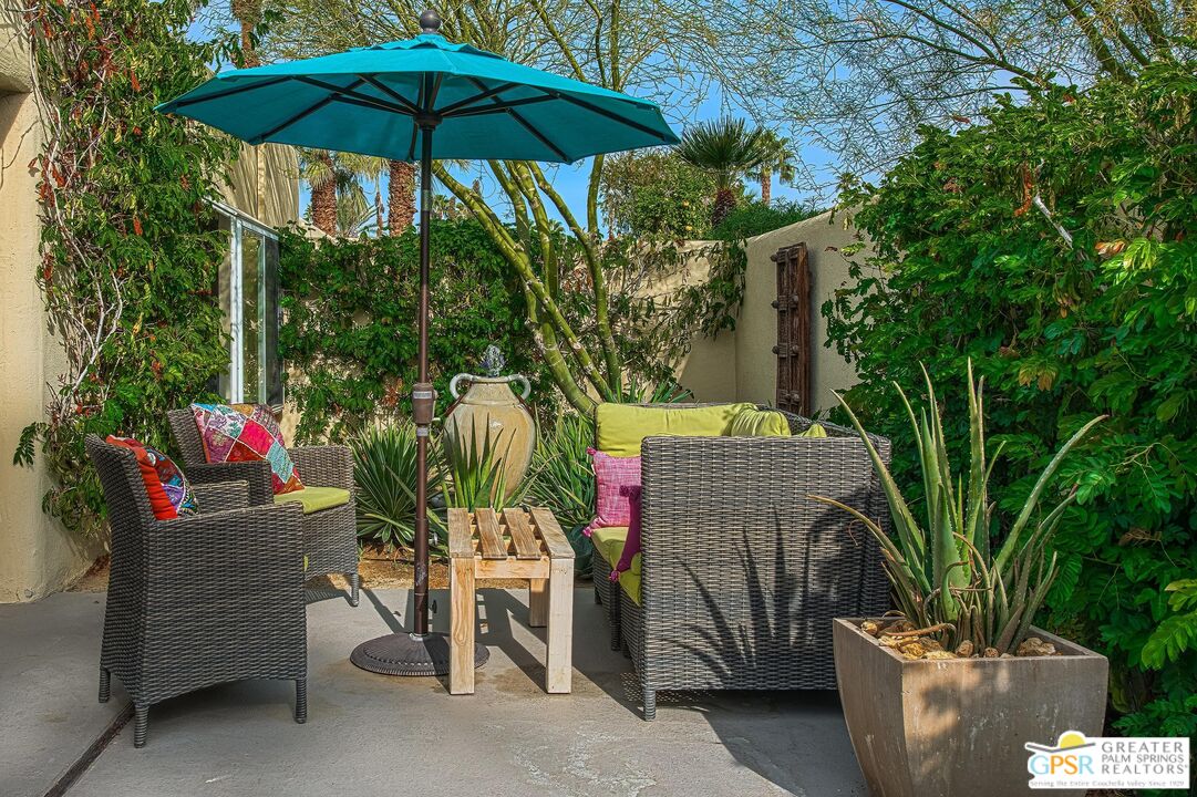 1177 East Alejo Road Palm Springs, CA 92262 - Photo 18 of 33 a patio with tables and chairs and a umbrella