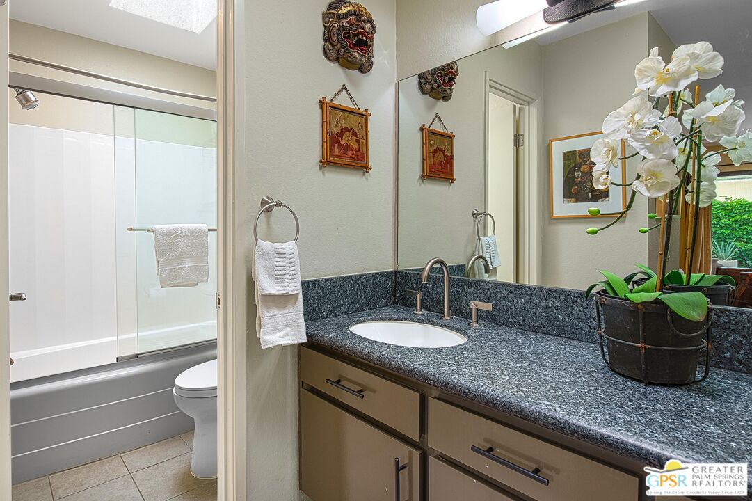 1177 East Alejo Road Palm Springs, CA 92262 - Photo 23 of 33 a bathroom with a granite countertop sink a large mirror and a bathtub