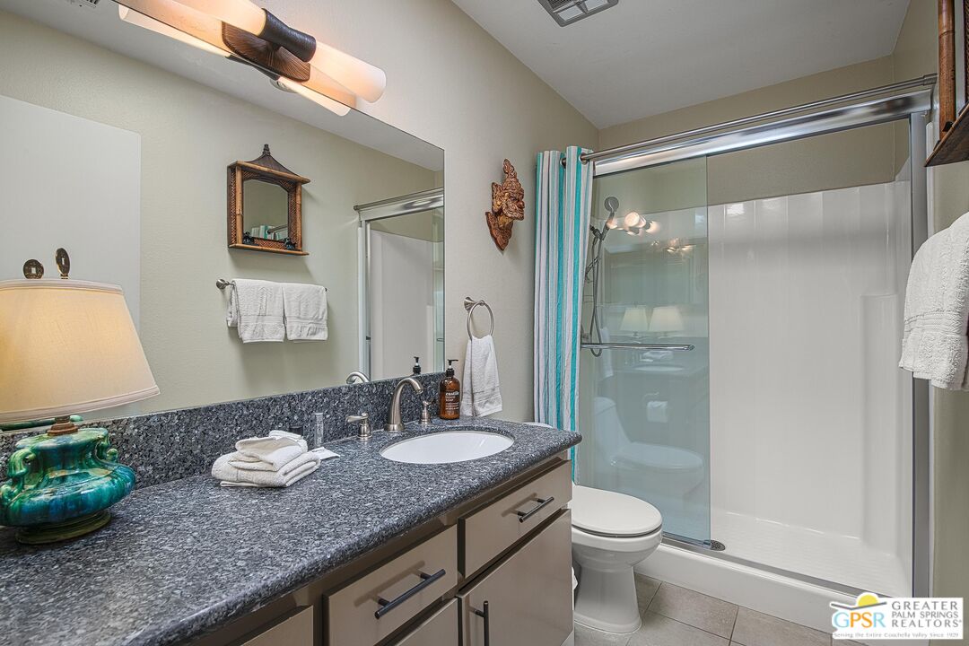 1177 East Alejo Road Palm Springs, CA 92262 - Photo 26 of 33 a bathroom with a granite countertop sink toilet and shower