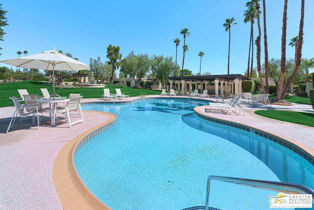 1177 East Alejo Road Palm Springs, CA 92262 - Photo 29 of 33 a view of a swimming pool with lawn chairs under an umbrella