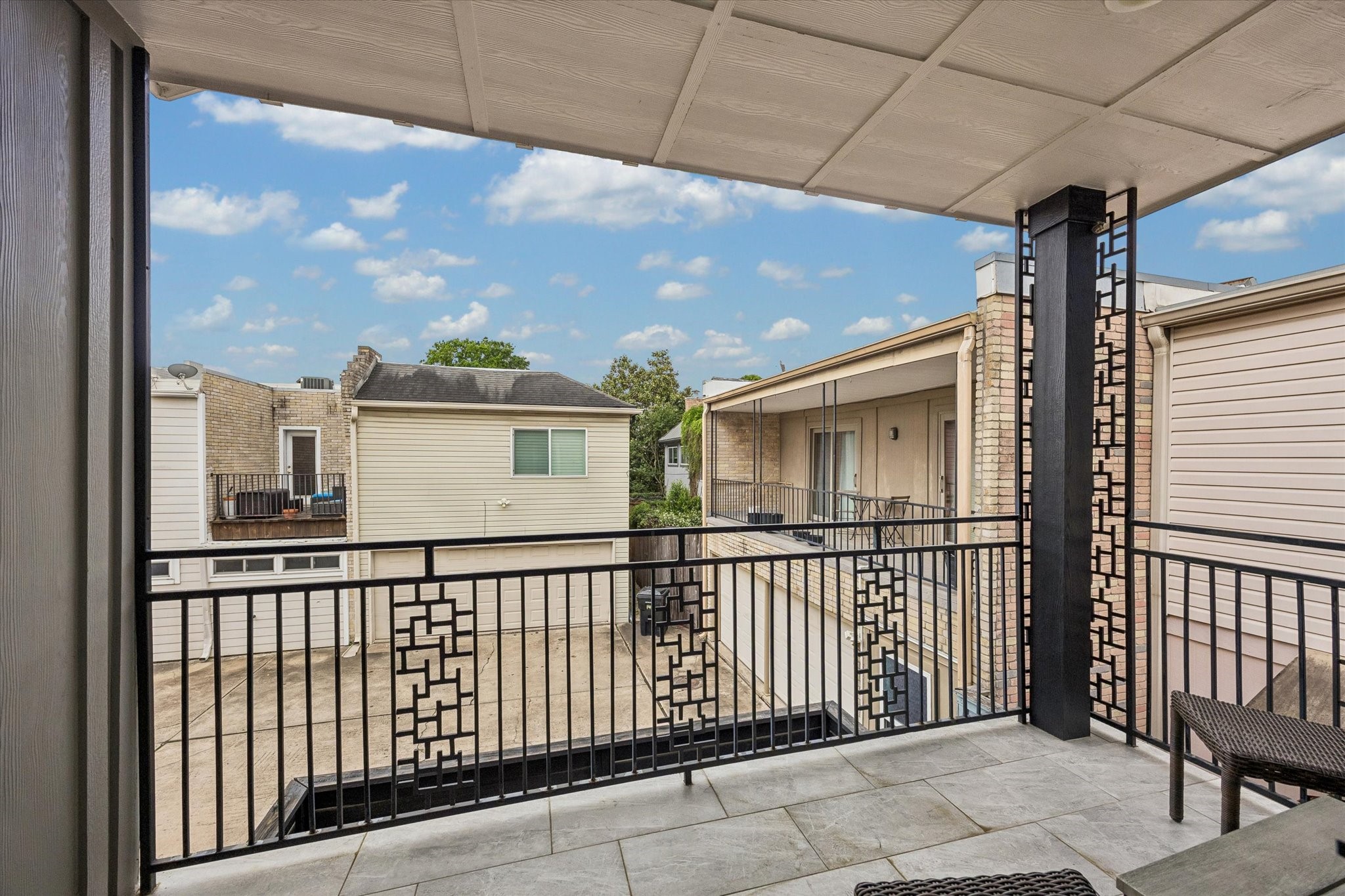 1420 Indiana Street Houston, TX 77006 - Photo 25 of 31 Spacious balcony with modern railing offers a view of neighboring homes. Ideal for relaxation, featuring a tiled floor and partial cover for shade.