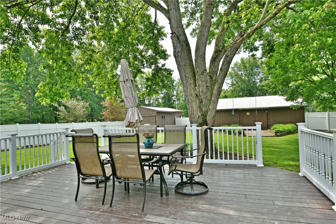 2847 Selkirk Bush Road Warren, OH 44481 - Photo 46 of 47 Wooden deck with outdoor dining area, a fenced backyard, and an outdoor structure