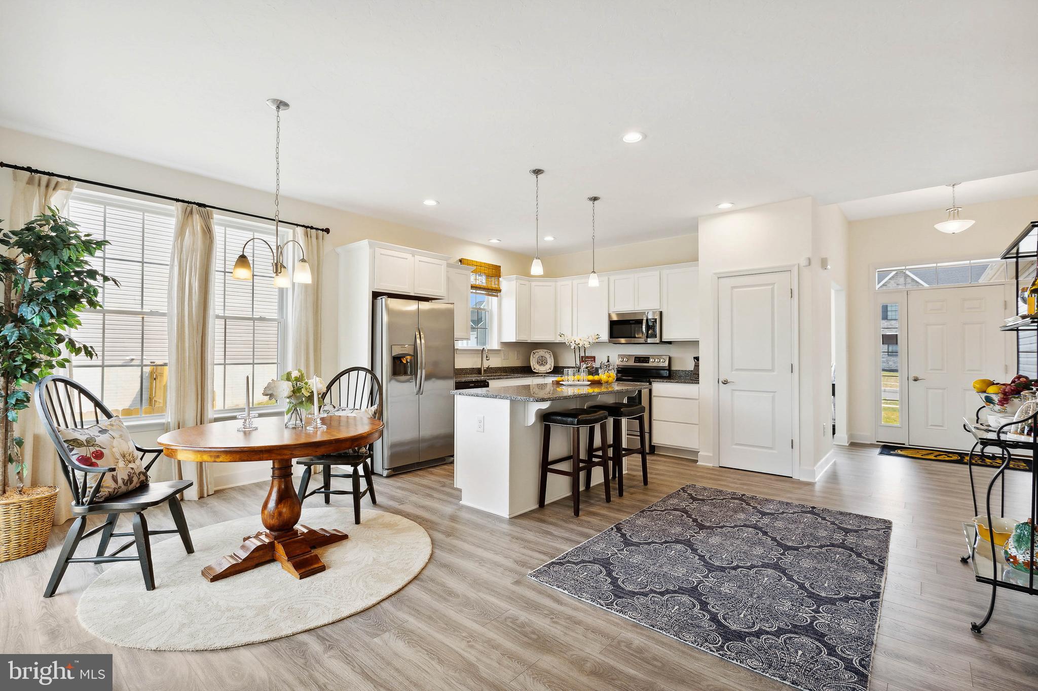 185 East Audubon Drive, Unit 177 Gettysburg, PA 17325 - Photo 11 of 36 a kitchen with stainless steel appliances kitchen island granite countertop a stove a refrigerator a sink a dining table and chairs with wooden floor