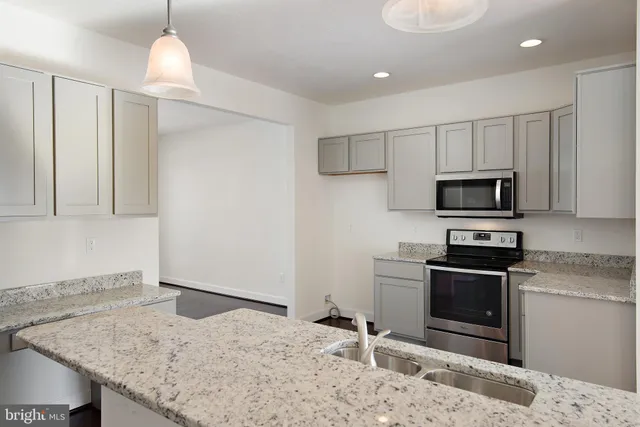 a kitchen with stainless steel appliances granite countertop a sink and a stove