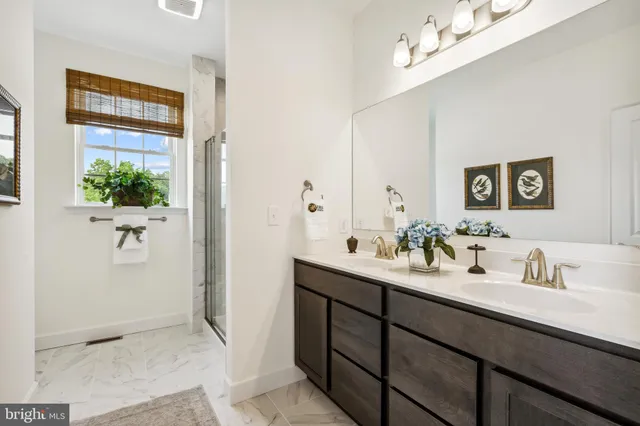 a en suite bathroom with a double vanity sink and a mirror