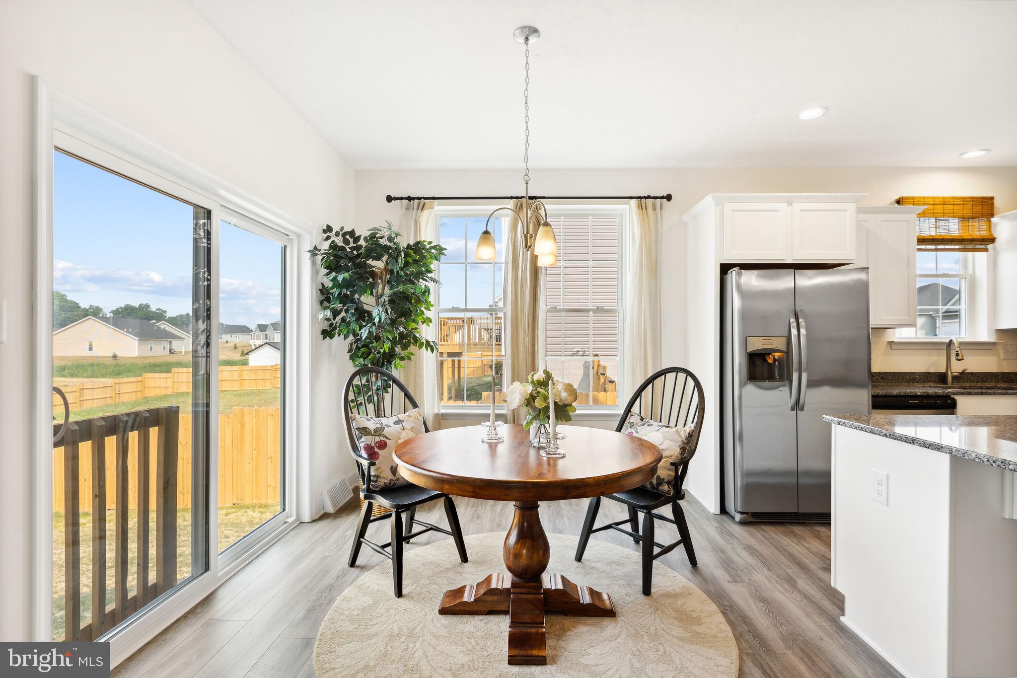 185 East Audubon Drive, Unit 177 Gettysburg, PA 17325 - Photo 25 of 36 a kitchen with stainless steel appliances granite countertop a table chairs and a refrigerator