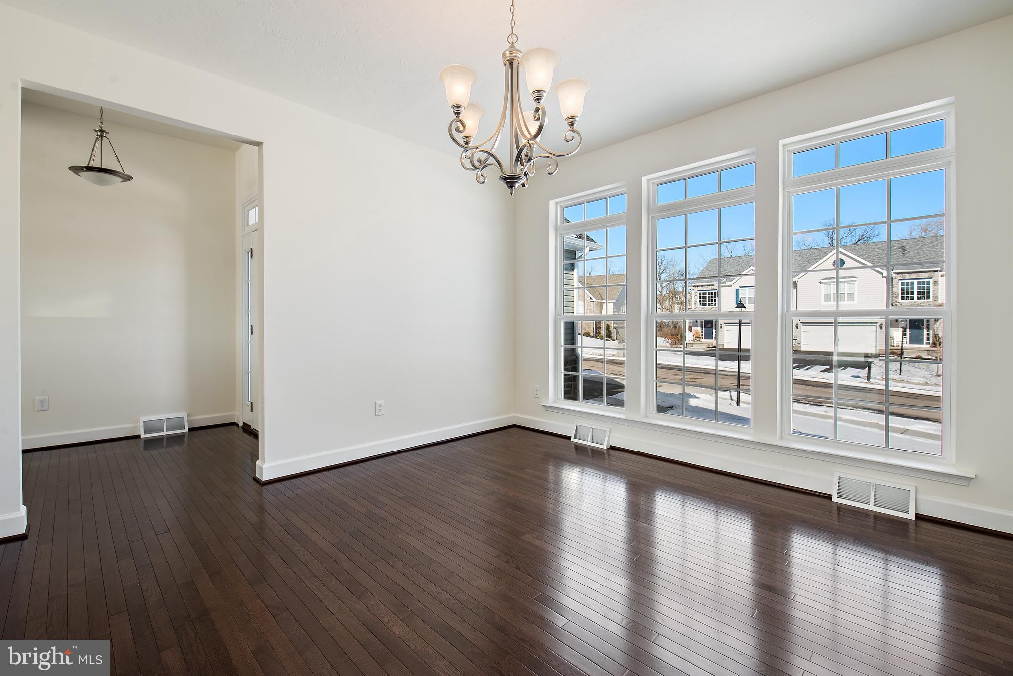 185 East Audubon Drive, Unit 177 Gettysburg, PA 17325 - Photo 4 of 36 a view of an empty room with a window and wooden floor