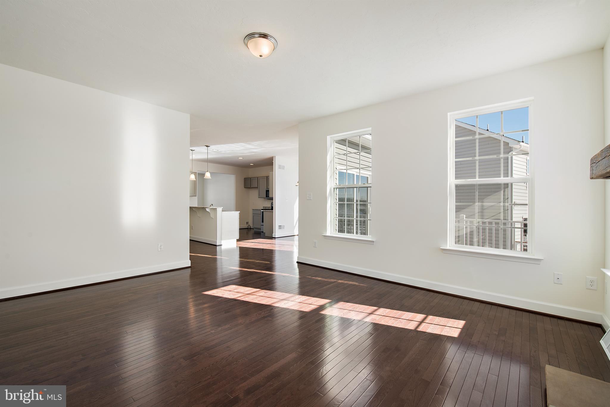 185 East Audubon Drive, Unit 177 Gettysburg, PA 17325 - Photo 5 of 36 an empty room with wooden floor and windows