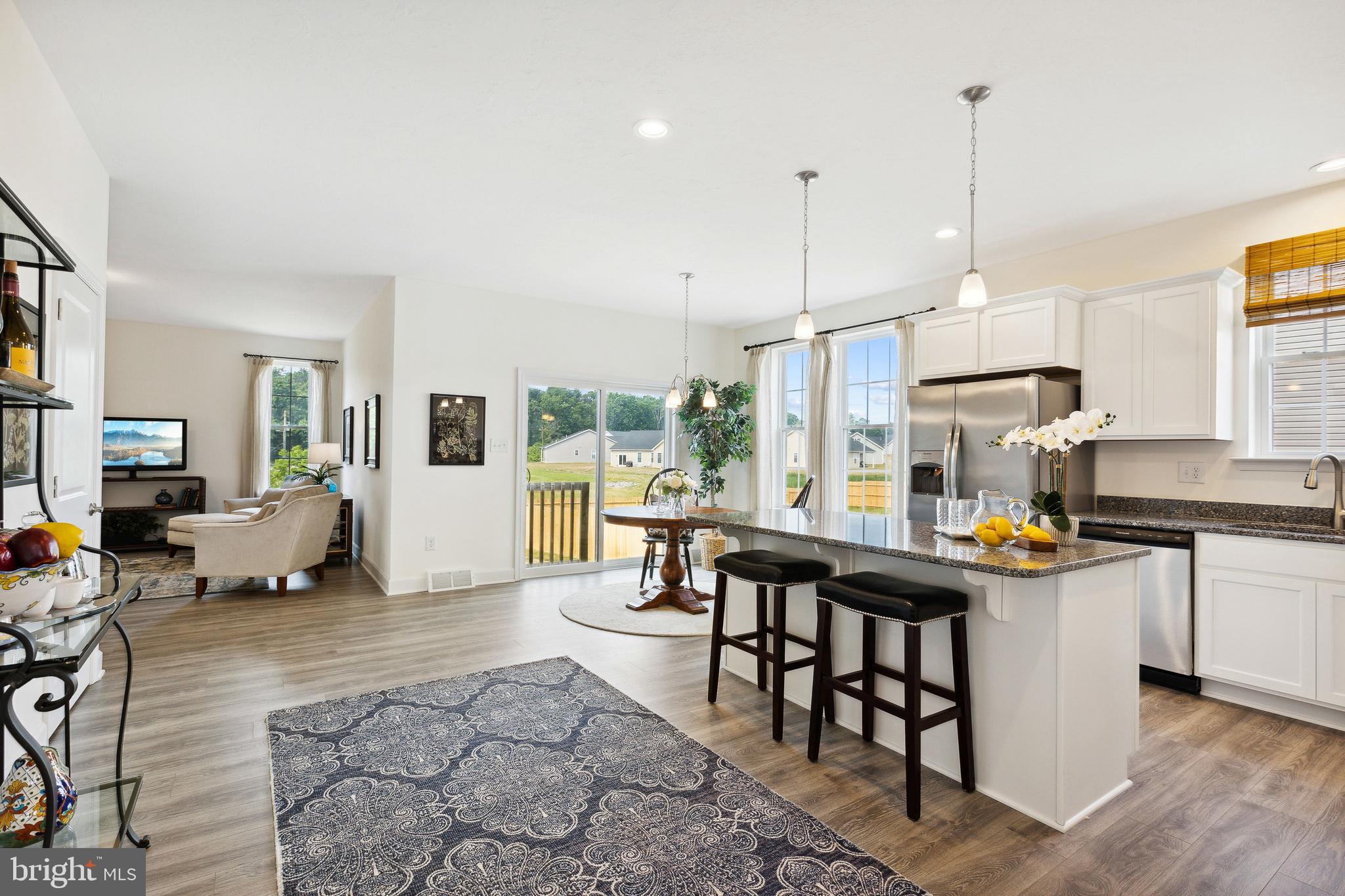 185 East Audubon Drive, Unit 177 Gettysburg, PA 17325 - Photo 9 of 36 a kitchen with stainless steel appliances granite countertop a stove top oven a sink a dining table and chairs