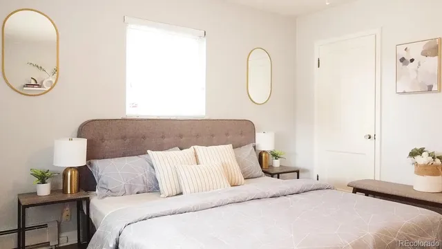 a bedroom with a bed a flowerpot and a window